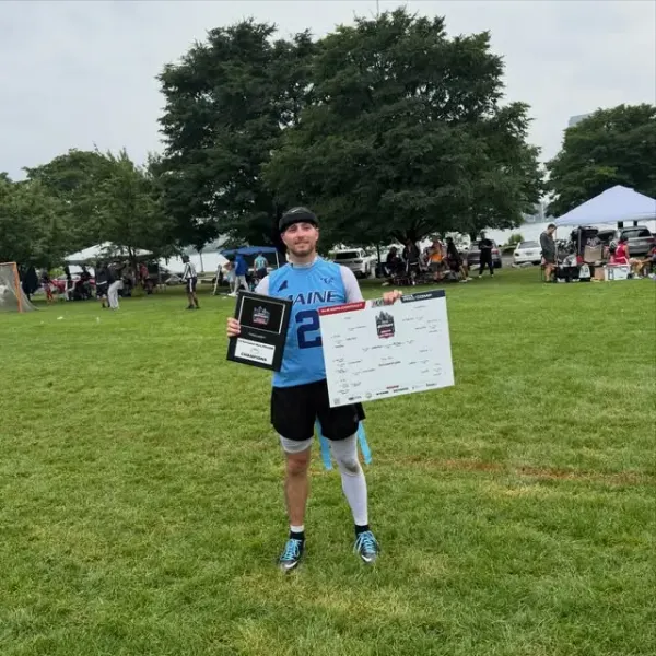 A 365 champion holding up a tournament bracket poster